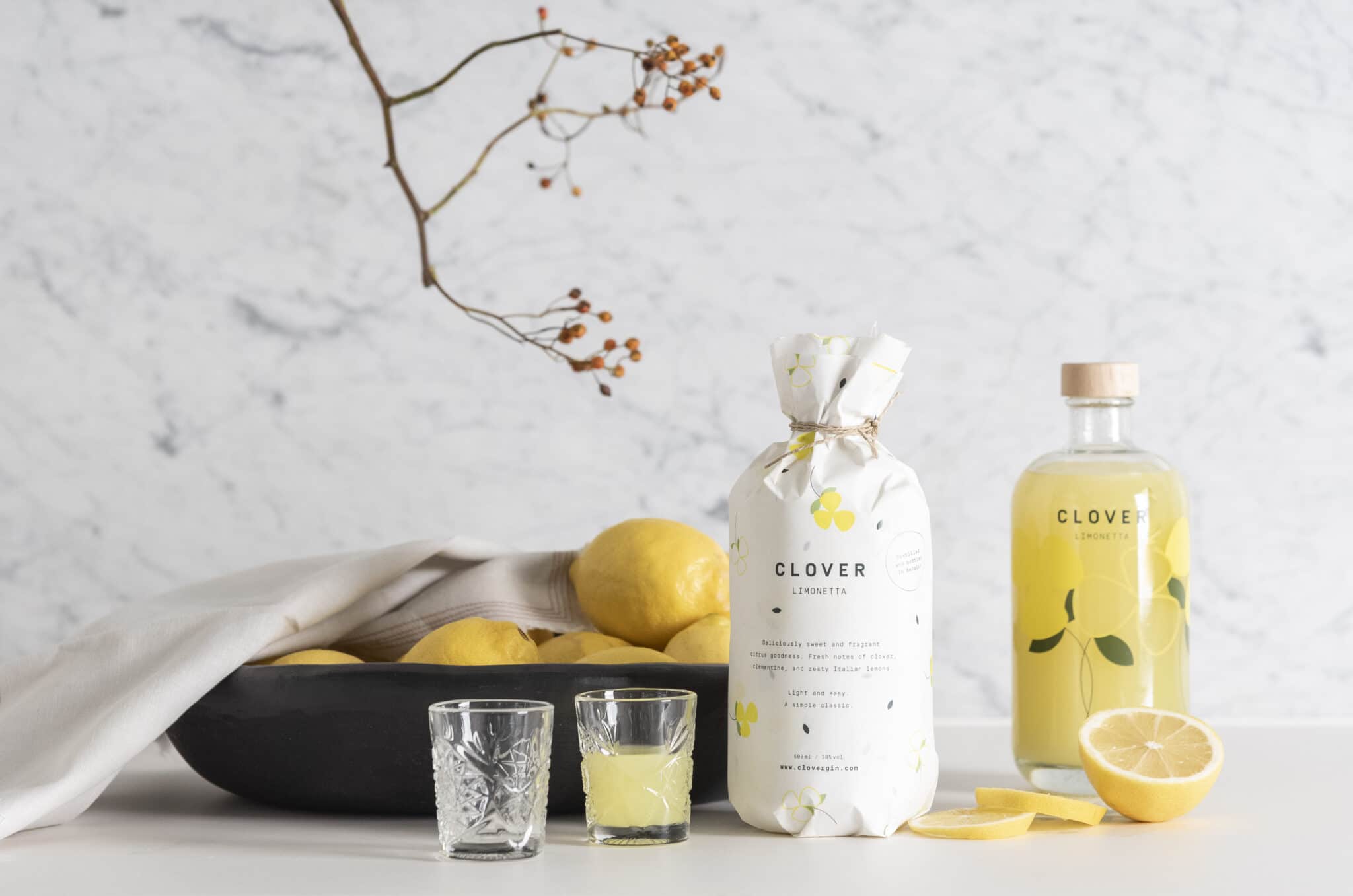 Clover gin fles met citroenen en glazen – premium Belgische gin met frisse citrus smaak